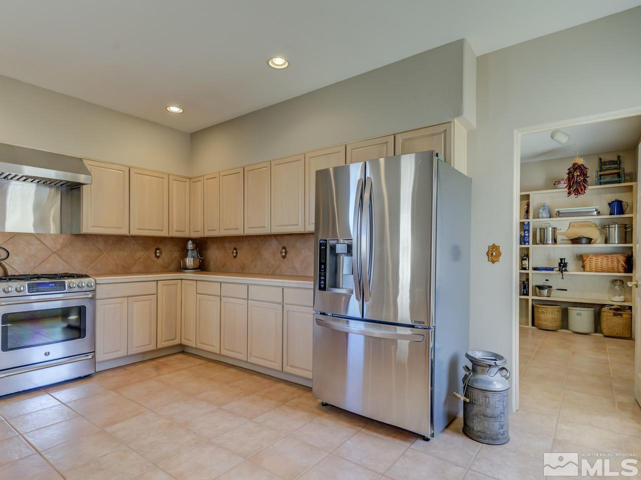 7280 Sage Canyon Road Reno, NV 89510 - Photo 8 of 23 a kitchen with stainless steel appliances a refrigerator and a stove top oven