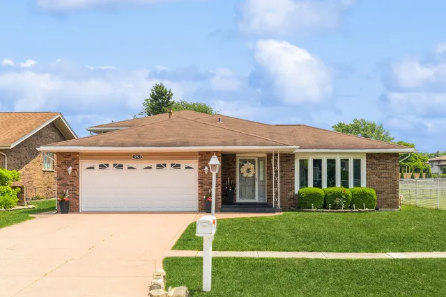a front view of a house with a garden and plants