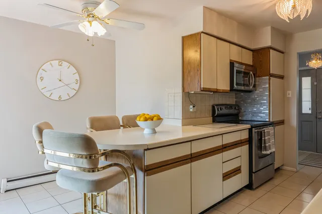 a kitchen with stainless steel appliances a stove a refrigerator and a dining table with painted walls