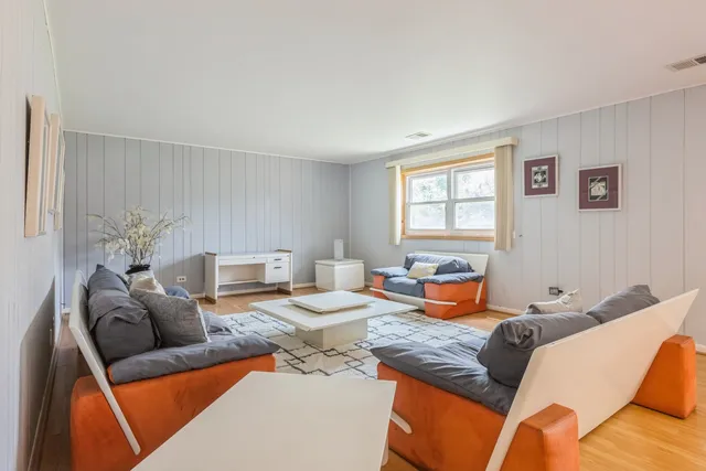 a living room with furniture kitchen view and a window