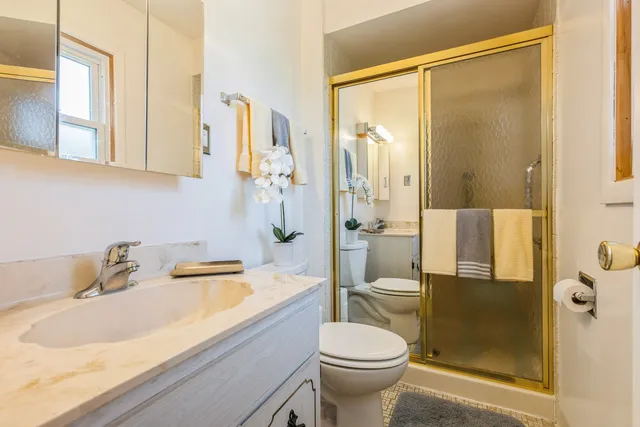 a bathroom with a sink a toilet and shower