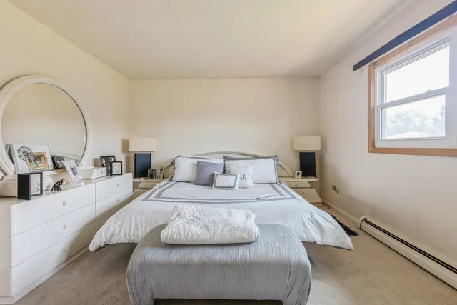 a bedroom with a bed and a large window