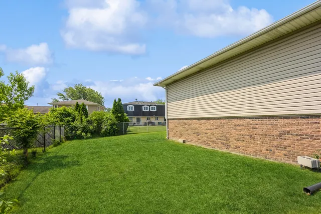 a view of a backyard with plants and large trees