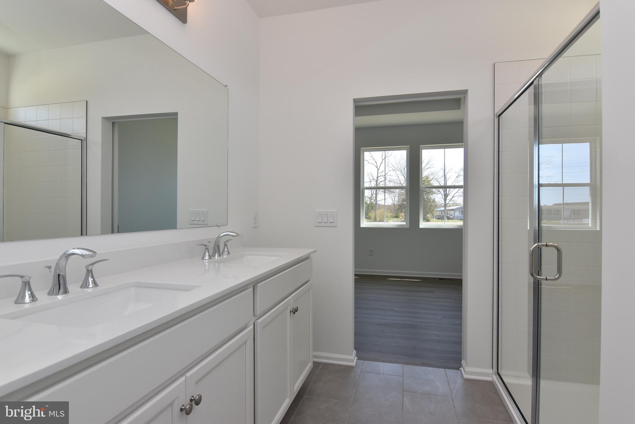 36366 Gate Drive Georgetown, DE 19947 - Photo 13 of 23 a en suite bathroom with a double vanity sink a mirror and a shower