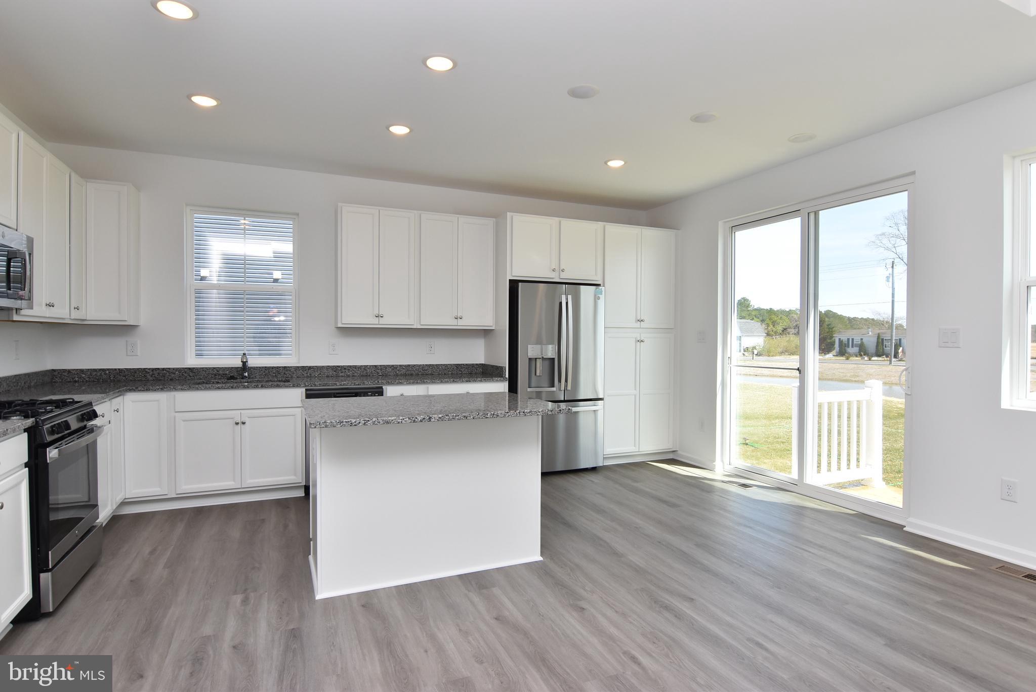 36366 Gate Drive Georgetown, DE 19947 - Photo 7 of 23 a kitchen with stainless steel appliances granite countertop a stove a sink and a refrigerator