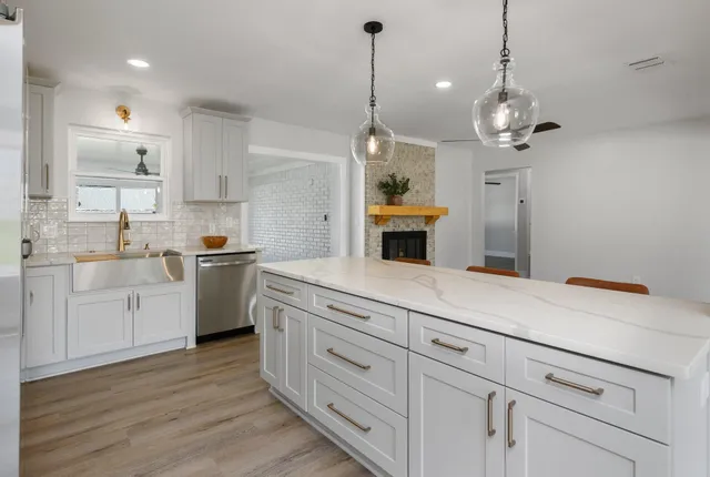 a kitchen with a white cabinets and chandelier