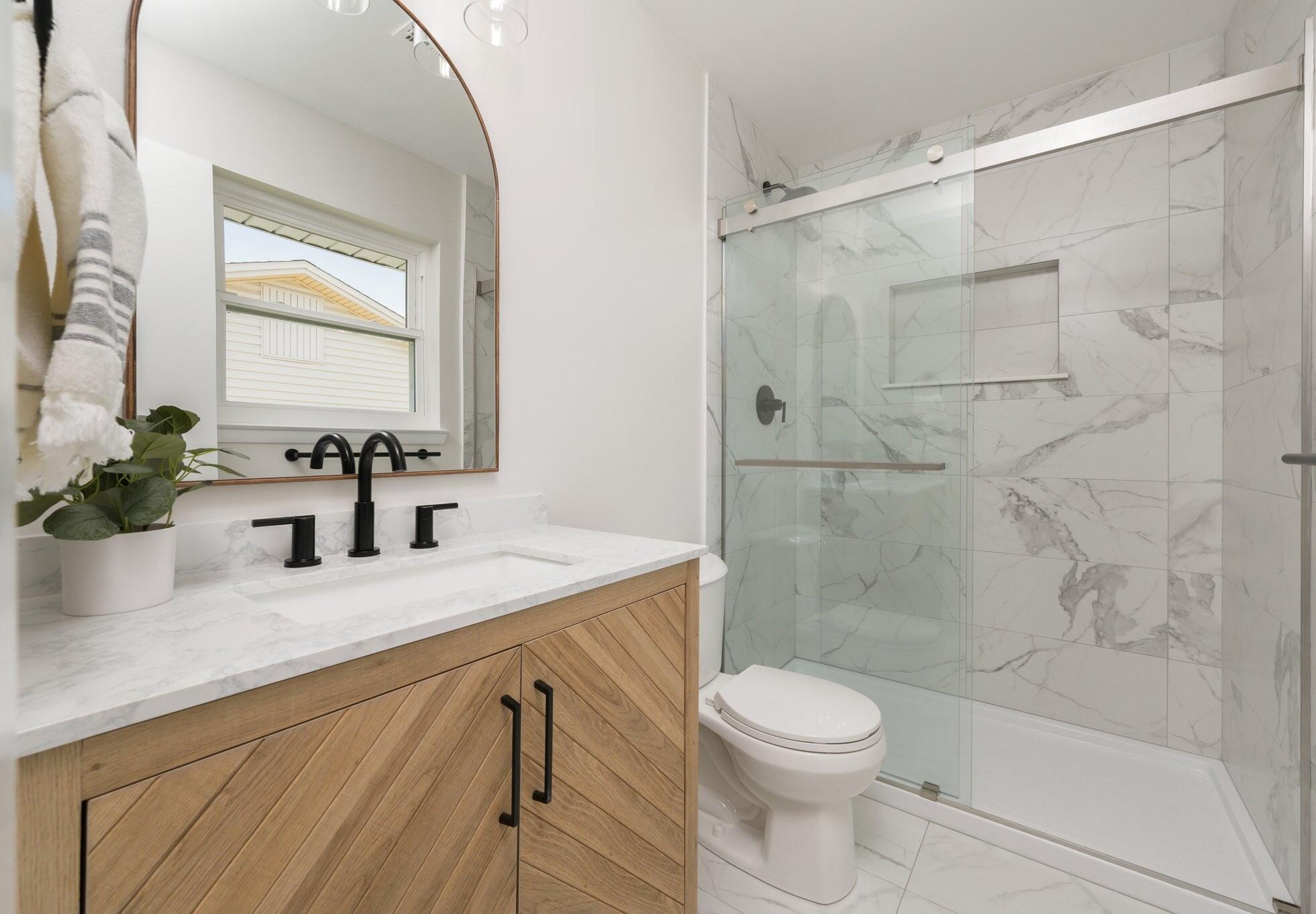 79 11th Street Shalimar, FL 32579 - Photo 18 of 36 a bathroom with a granite countertop sink a toilet and shower