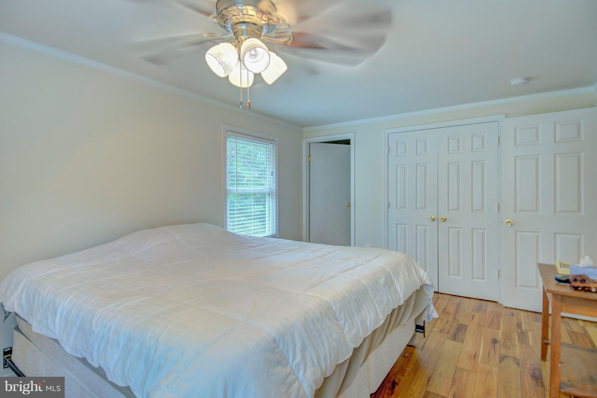 7031 Briscoe Turn Road Owings, MD 20736 - Photo 17 of 29 a bedroom with a large bed and a chandelier