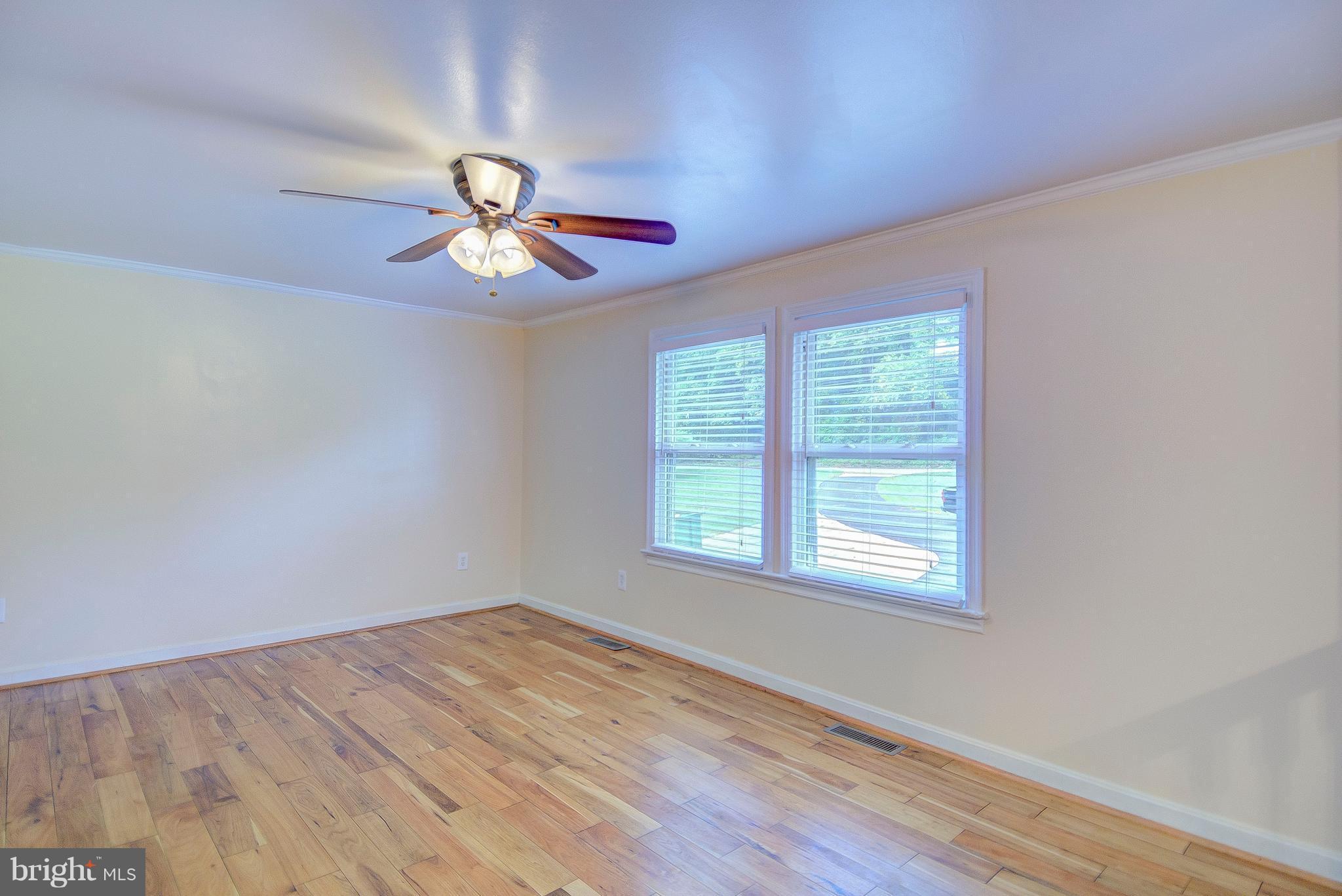 7031 Briscoe Turn Road Owings, MD 20736 - Photo 5 of 29 a view of empty room with wooden floor and fan