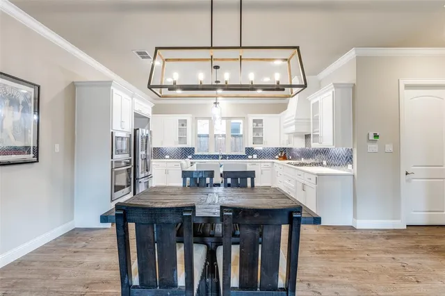 a kitchen with stainless steel appliances granite countertop a kitchen island hardwood floor and a sink