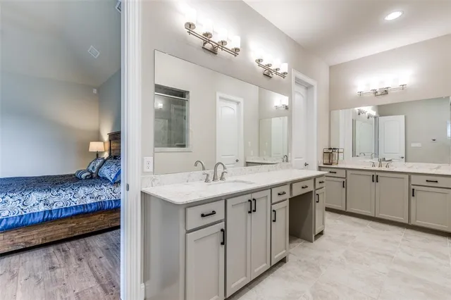 a spacious bathroom with a granite countertop sink a mirror and a vanity