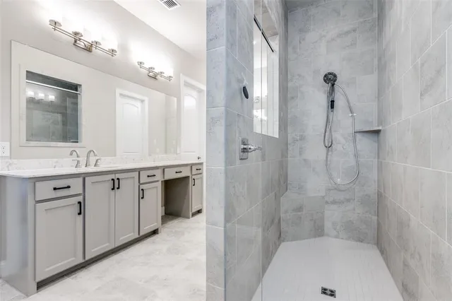 a bathroom with a granite countertop sink a mirror a bathtub and shower