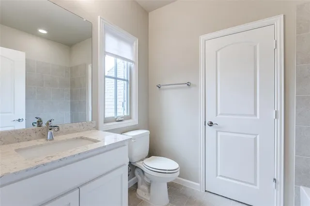 a bathroom with a granite countertop toilet a sink and a mirror