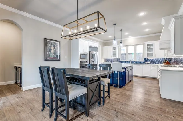 a view of a dining room and livingroom with furniture wooden floor a chandelier