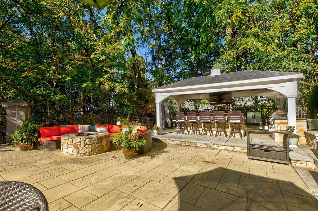 12 Cameron Way Methuen, MA 01844 - Photo 37 of 42 a view of a patio with dining table and chairs under an umbrella with large trees