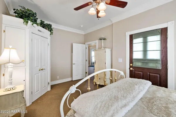 a large bedroom with wooden floor and chandelier