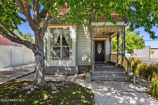 a front view of a house with a tree