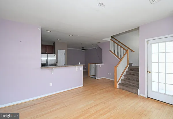 a view of a livingroom with wooden floor and stairs