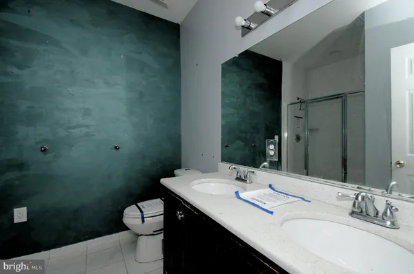 a bathroom with a double vanity sink toilet and a mirror