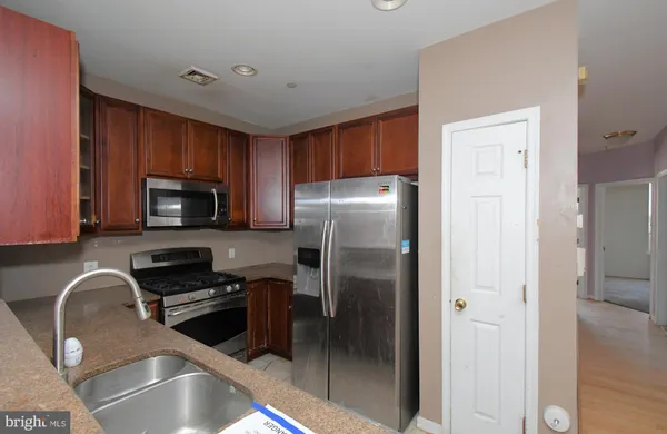 a kitchen with a refrigerator sink and cabinets