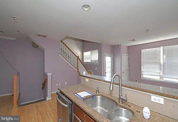 a kitchen with granite countertop a sink and a wooden floor