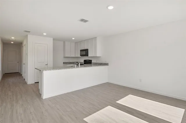 a view of kitchen with center island and wooden floor