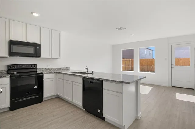 a kitchen with granite countertop a stove and a sink