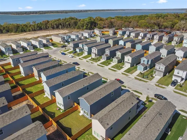 a view of a hallway with wooden floor and a bathroom