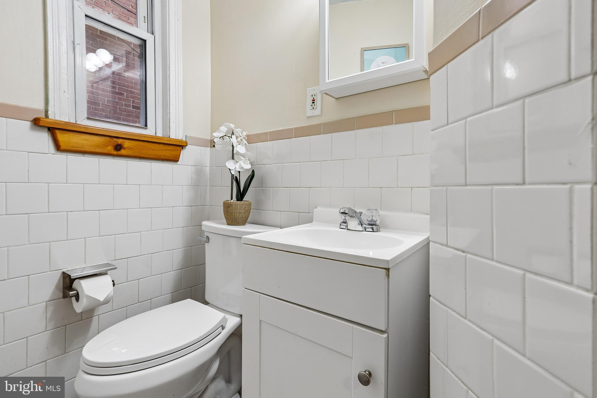 147 Denison Street Baltimore, MD 21229 - Photo 13 of 21 a bathroom with a sink toilet and window