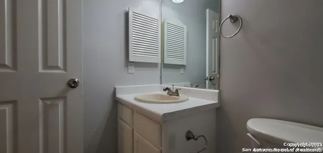 a bathroom with a toilet sink and mirror