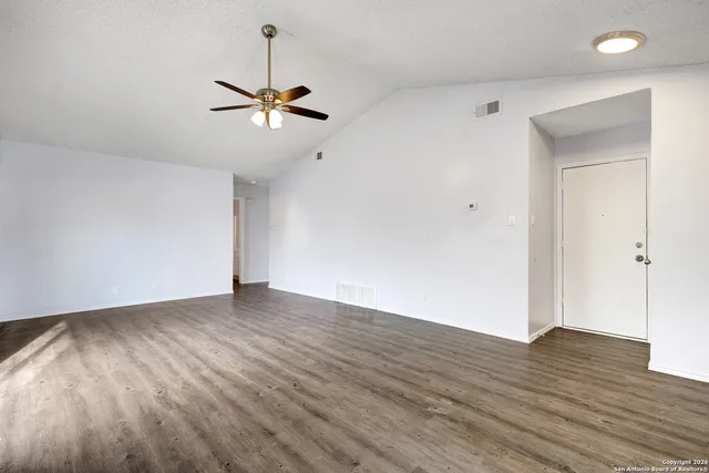 a view of empty room with wooden floor