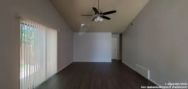 a view of a hallway with wooden floor and a ceiling fan
