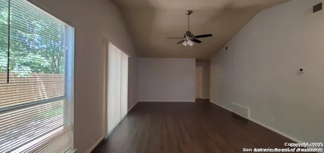 a view of a hallway with wooden floor and a window