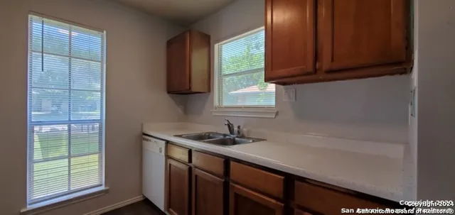 a kitchen with a sink a window and cabinets