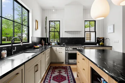 a kitchen with a sink stove top oven and cabinets