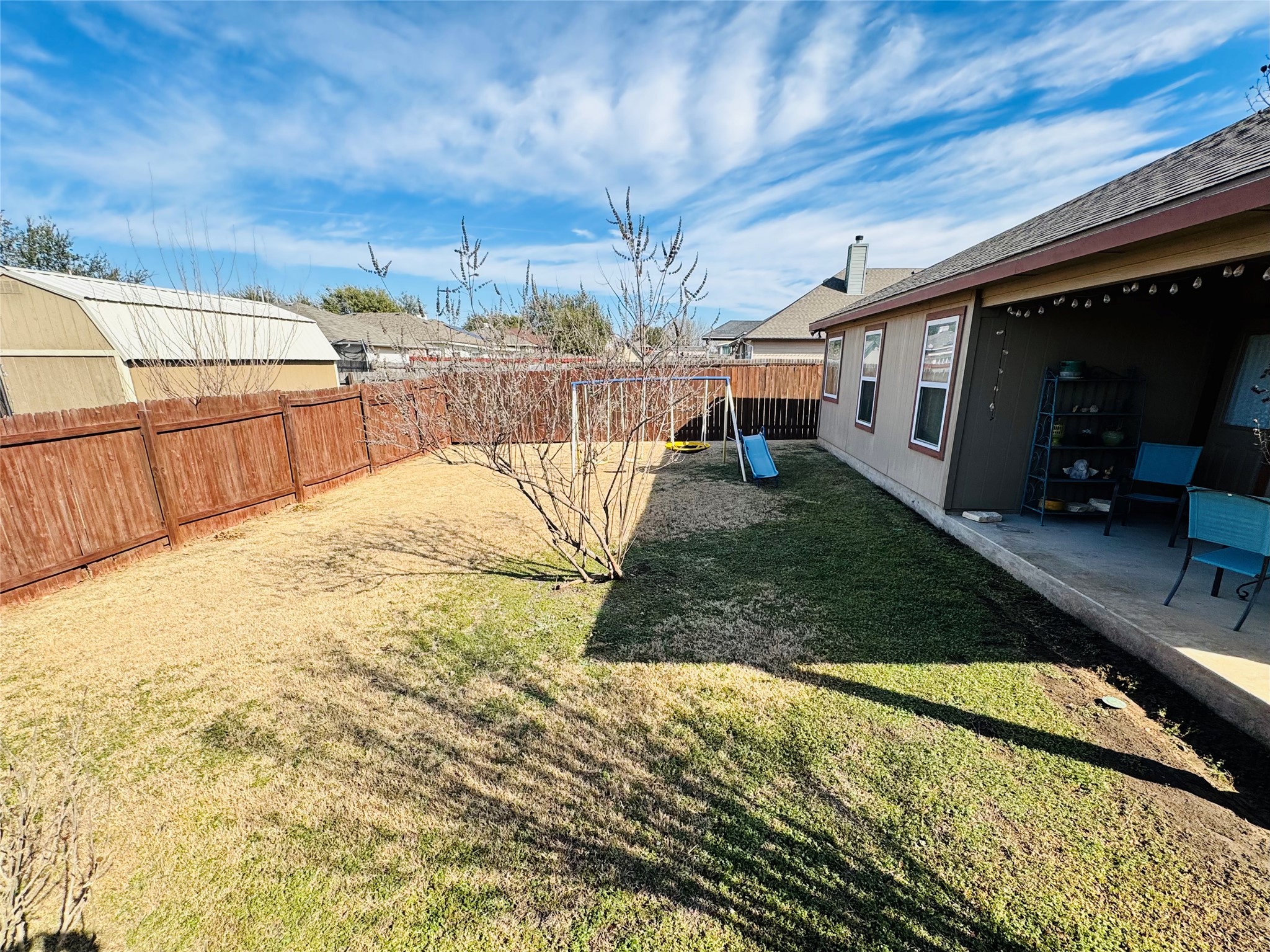 413 Gettysburg Loop Elgin, TX 78621 - Photo 30 of 32 Fenced backyard with a playground and a patio area