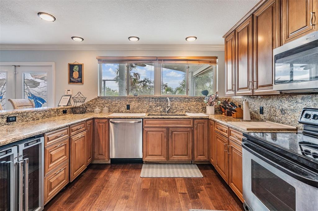 815 2nd Avenue Northwest Ruskin, FL 33570 - Photo 14 of 86 a kitchen with stainless steel appliances granite countertop wooden cabinets stove top oven and sink