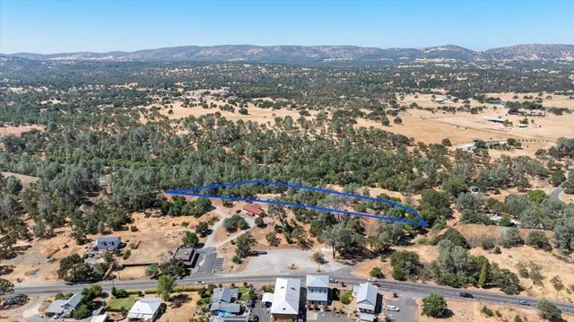 an aerial view of residential house with parking and mountain view