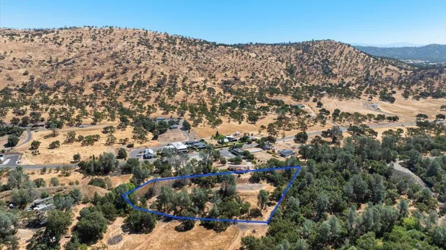 an aerial view of mountain with residential house and green space