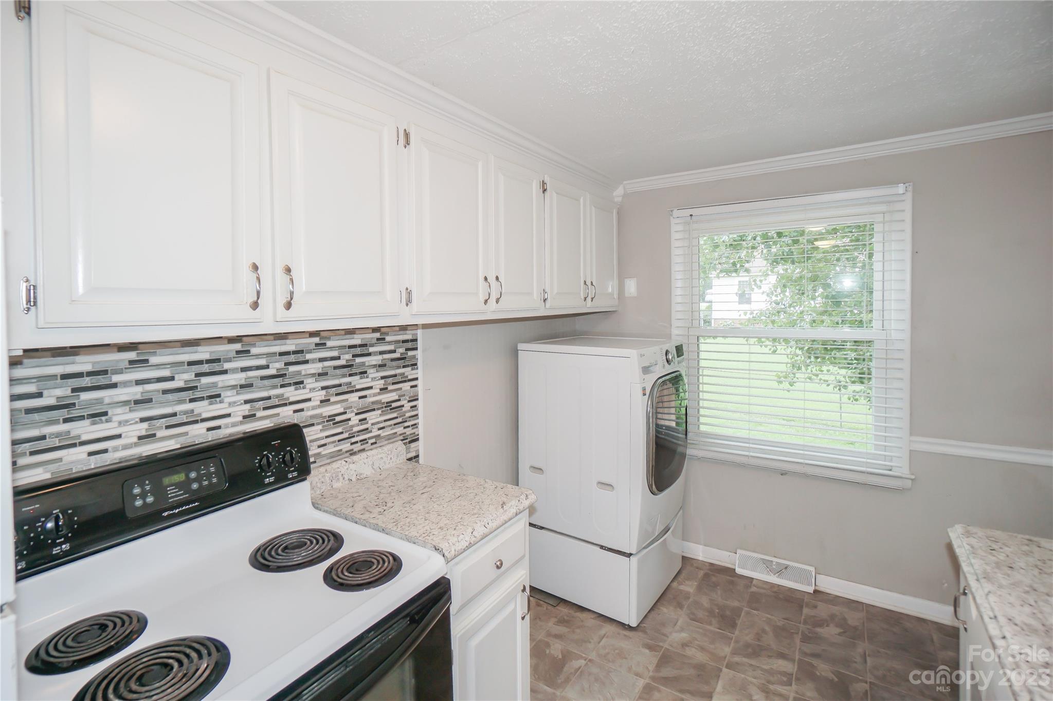720 Flint Street Rock Hill, SC 29730 - Photo 13 of 20 a kitchen with a stove a refrigerator and a white cabinets