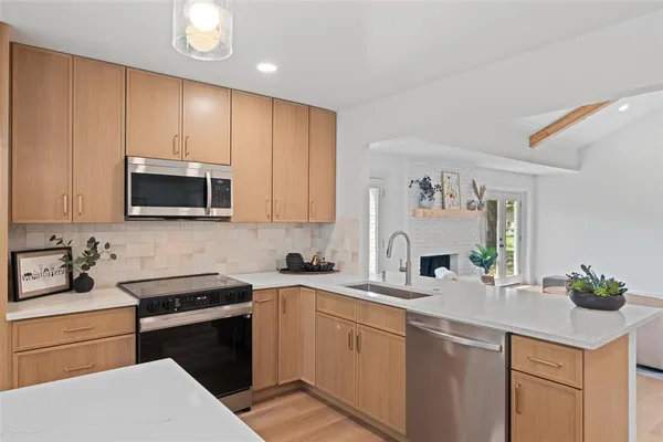 a kitchen with a sink a microwave and cabinets