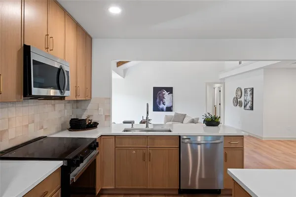 a kitchen with stainless steel appliances a sink stove and microwave