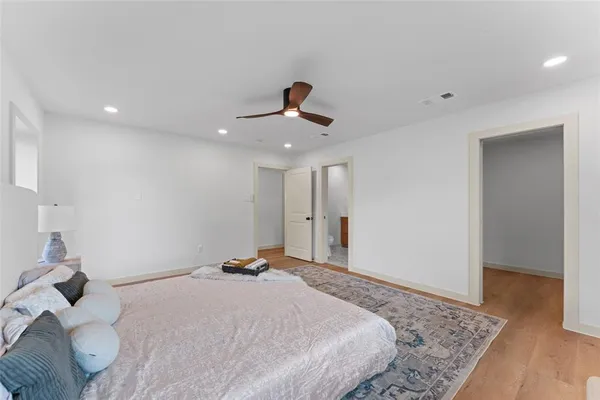 a bedroom with a bed and wooden floor