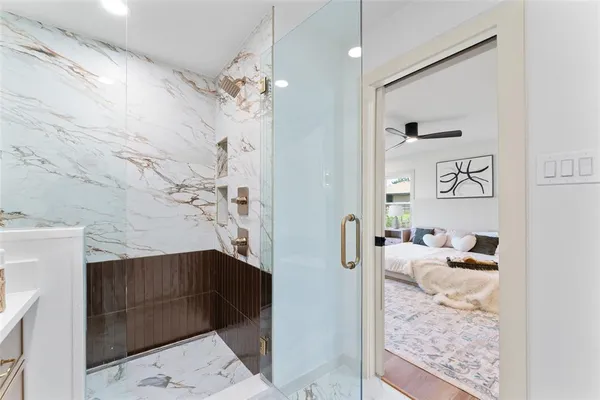 a bathroom with a granite countertop sink a mirror and shower