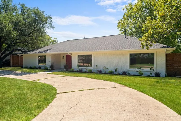 a front view of a house with a garden and yard
