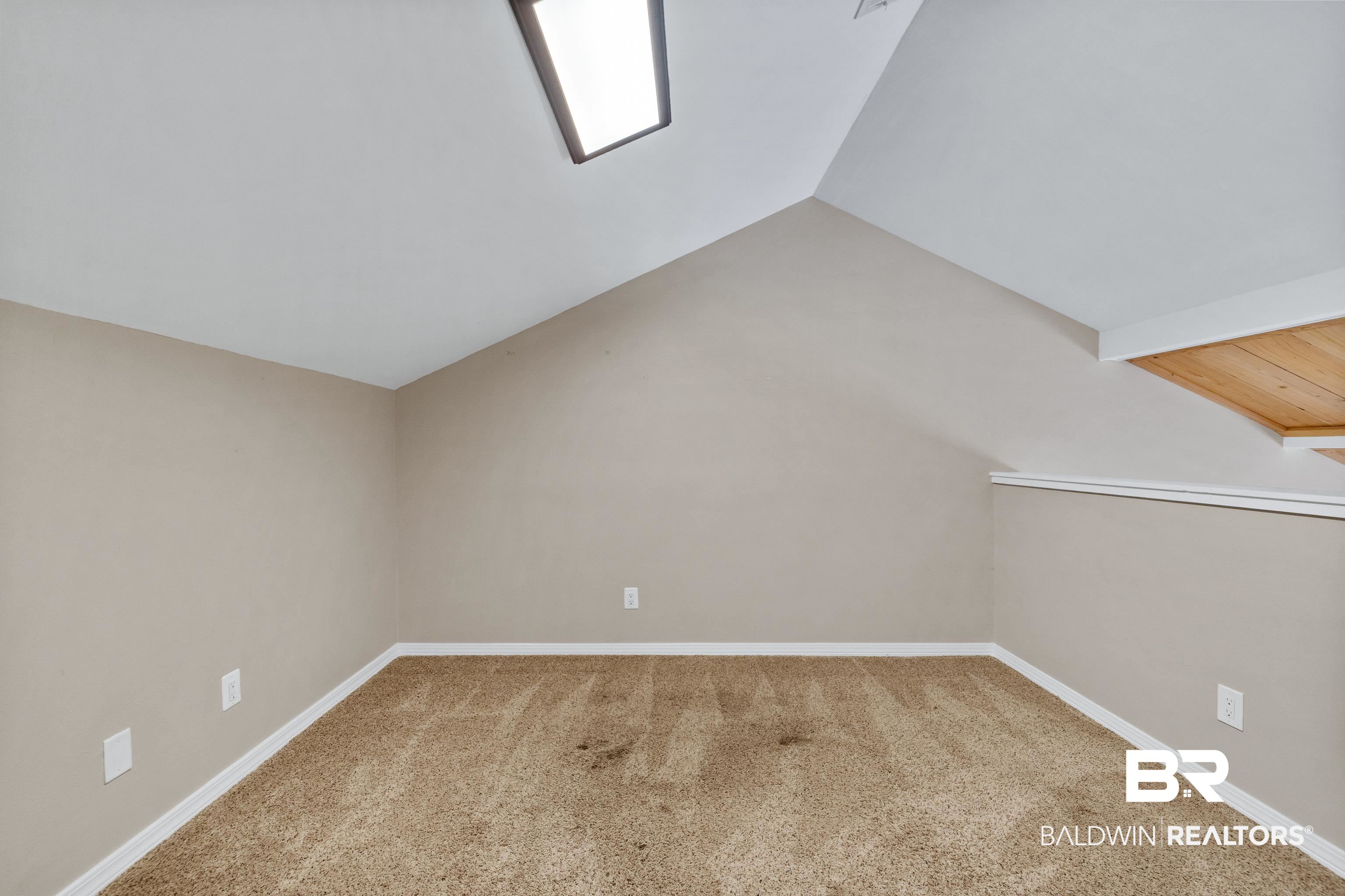 1701 Regency Road, Unit 111 Gulf Shores, AL 36542 - Photo 19 of 29 Additional living space with lofted ceiling and carpet floors