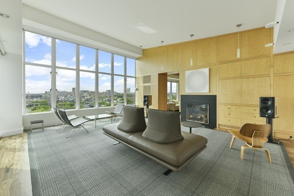 a living room with fireplace furniture and a floor to ceiling window