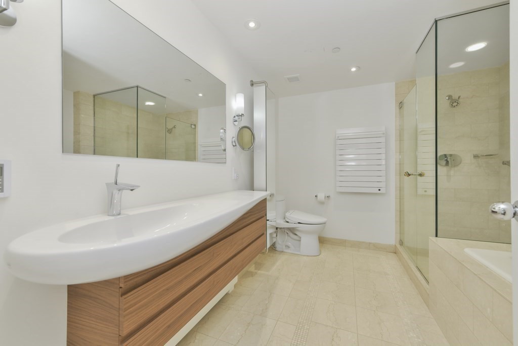 505 Tremont Street, Unit 904 Boston, MA 02116 - Photo 13 of 16 a bathroom with a double vanity sink toilet mirror and bathtub