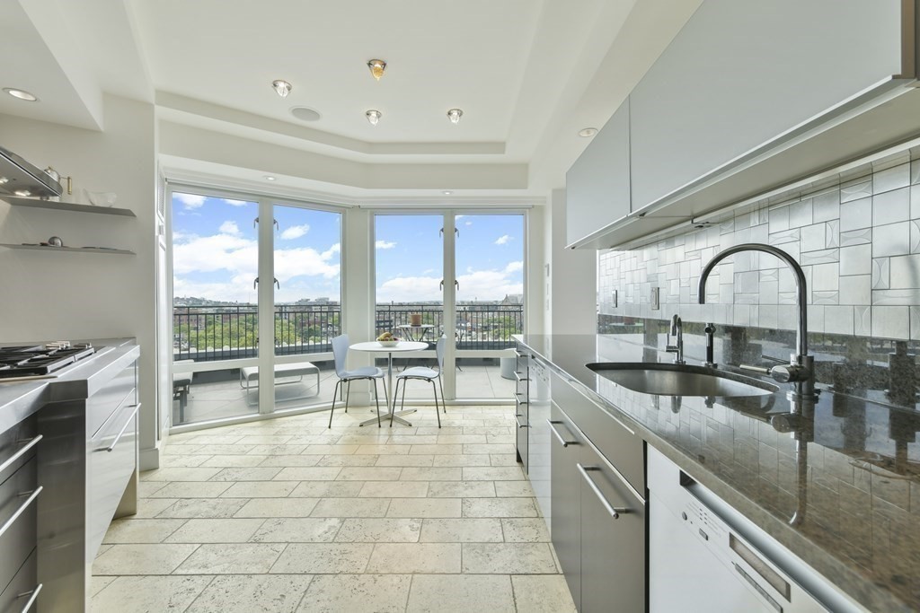 505 Tremont Street, Unit 904 Boston, MA 02116 - Photo 10 of 16 a open kitchen with stainless steel appliances granite countertop a stove white cabinets a dining table and chairs with the wooden floor