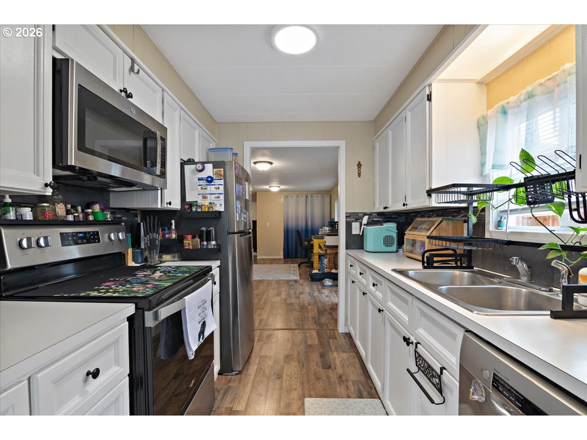 5355 River Road North, Unit 60 Keizer, OR 97303 - Photo 12 of 29 a kitchen with stainless steel appliances granite countertop a stove a sink and a microwave